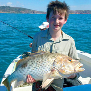 young child hold fish on charter trip townsville