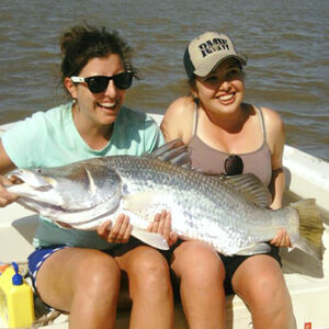 Two women holding Big Barra on Fishing Charter trip Townsville